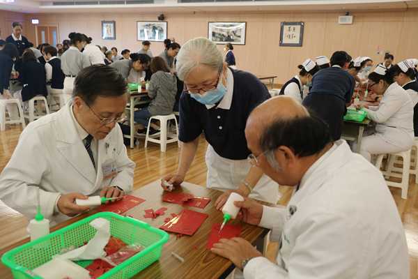 同仁們在第四聯區師姊們的指導下，製作完成福慧紅包。（馬順德攝）