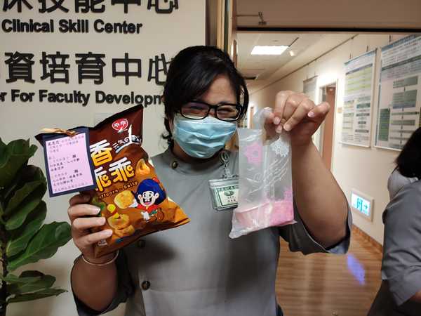 教學部陳美菊收到點心後,開心與乖乖及和菓子合照。(江柏緯攝)