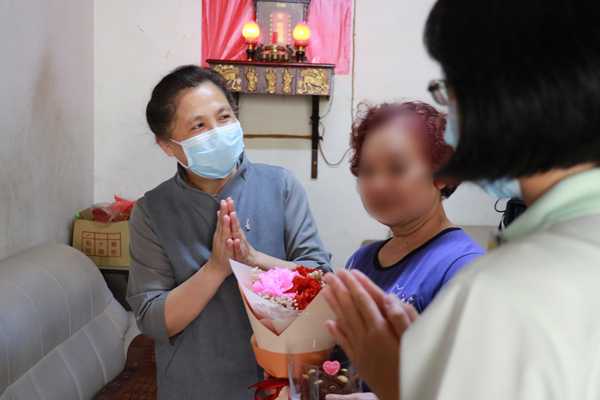 護理之家負責人莊淑婷(右圖:左一)帶著同仁,將溫馨盛開的康乃馨和蛋糕送給弱勢家庭長輩。(賴廷翰攝)