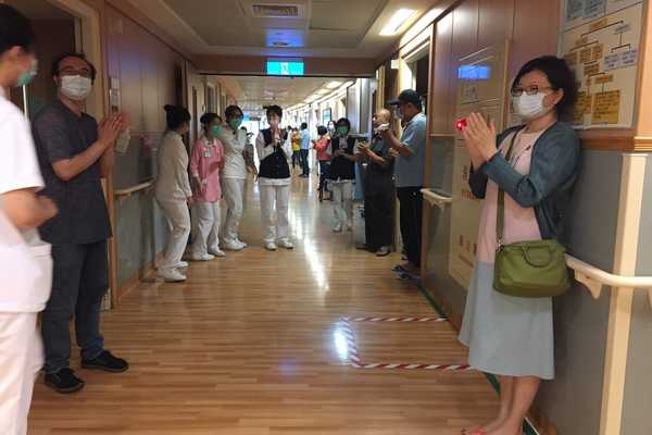 病房區家屬聽到簡院長廣播邀請,走到病房外,向護理師鼓掌致意。(何亞蓁攝)