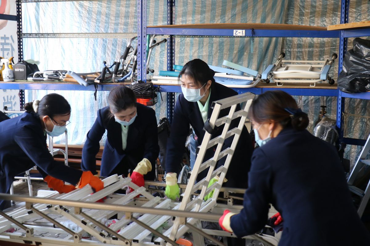 護理部主任李玉茹（右二）與護理之家越南籍照服員合力清消病床。