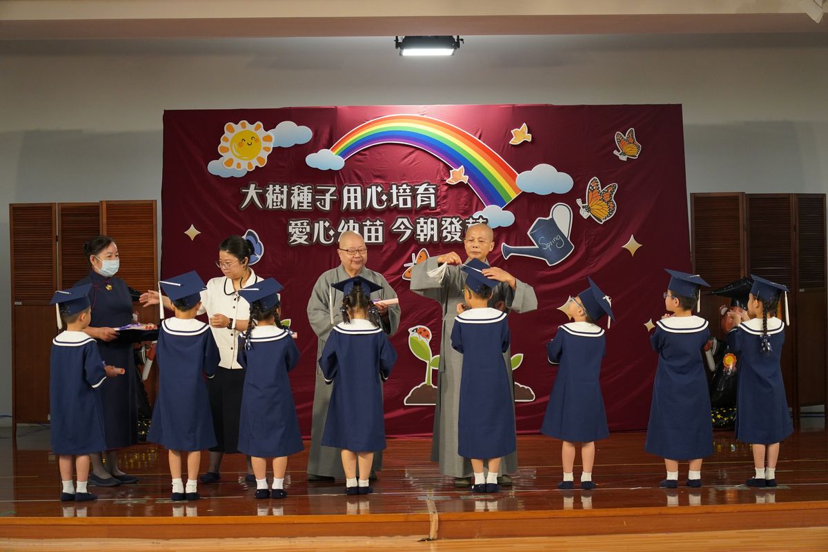 靜思精舍德旭師父（後左）與德守師父（後右）為畢業生撥穗、頒發畢業證書，祝福孩子在人生旅程中持續茁壯成長。