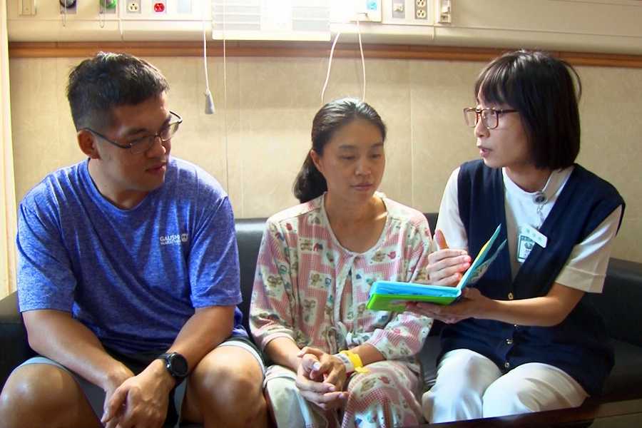 護理師指導產婦夫妻透過洗澡書和寶寶進行第一次親子共讀。（江柏緯攝）