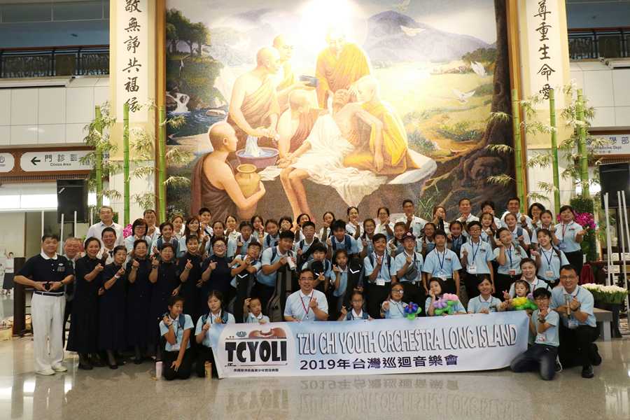 樂團演出後在佛陀問病圖前合影。（賴廷翰攝）