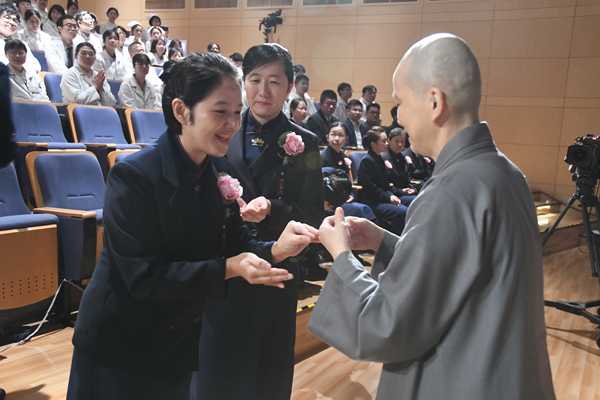 德悅師父替陳詩華主任掛佛珠。（施龍文攝）