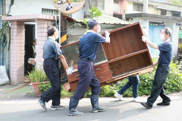 社區師兄合力清運大型家具。（曾秀英攝）