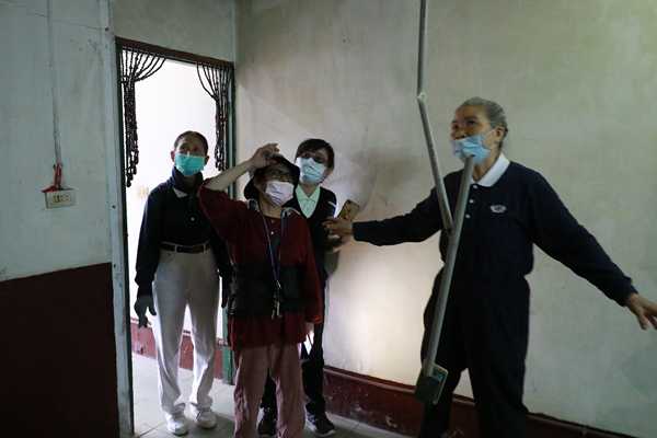 打掃完成後，李女士（戴帽者）跟著社區師姊進屋，直說很滿意、很感恩。（曾秀英攝）
